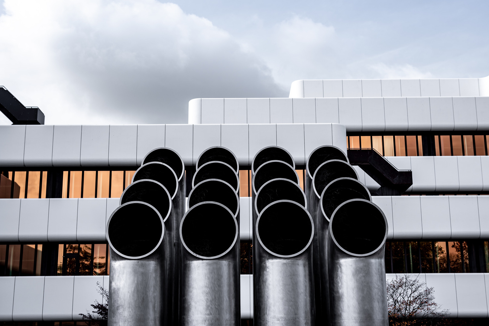 Extremely large pipes in front of a building coming from the ground
